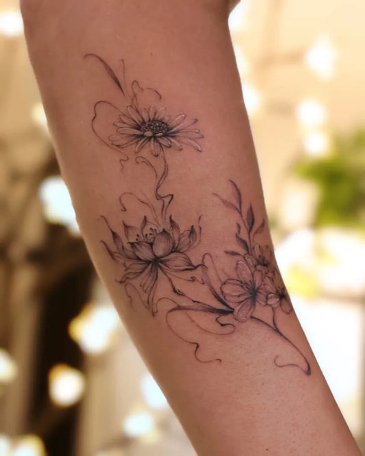 Small Fine Line Daisy and Lotus Women Arm by @vivi_tattooer