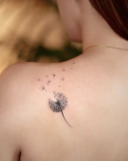 Small Fine Line Dandelion Seeds Tattoo on Women Shoulder by @kuri.tattooart