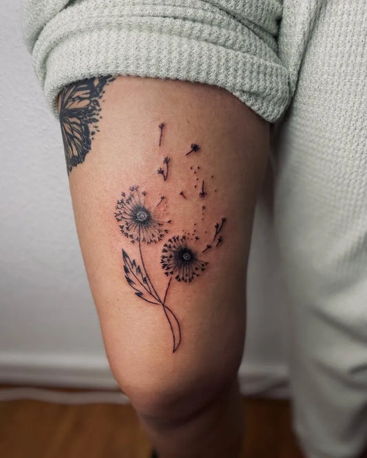Small Fine Line Dandelion Tattoo on Women Thigh by @johnetattoos