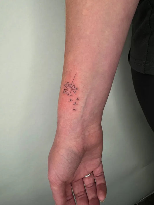 Small Fine Line Dandelion Tattoo on Women Wrist by @francielitattooart