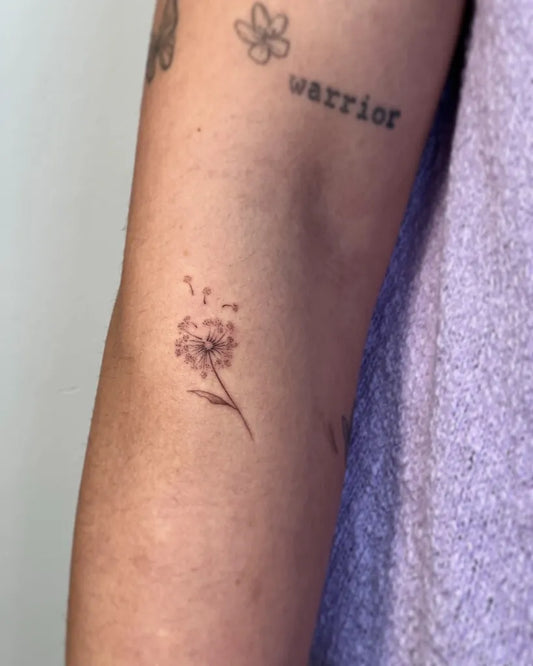Small Fine Line Dandelion Word Tattoo on Women Arm by @nothingsrs