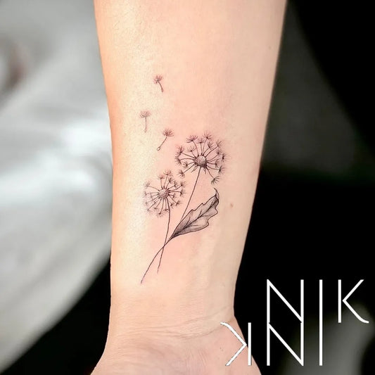 Small Fine Line Dandelion and Seeds Tattoo on Women Arm by @nikfinelinetattooartist