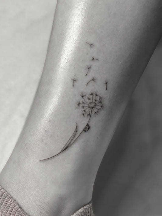 Small Fine Line Dandelion and Seeds Tattoo on Women Leg by @artofhaliepowers