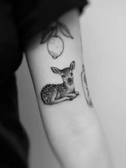 Small Fine Line Deer and Lemon Tattoo on Women Arm by @aksamitnie.ink