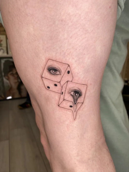 Small Fine Line Dice with Eyes Tattoo on Women Thigh by @heloisegeslain
