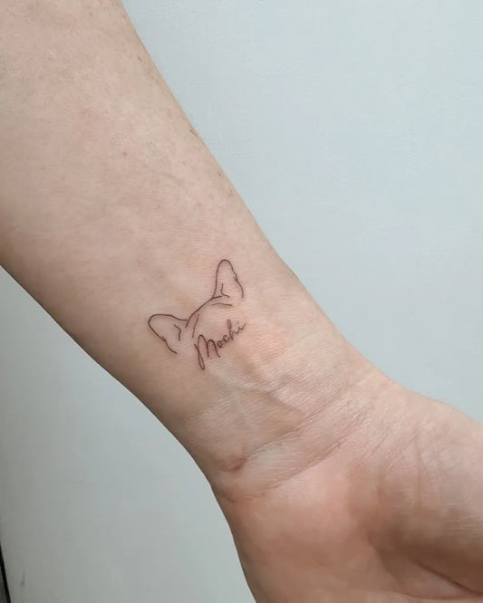 Small Fine Line Dog and Name Tattoo on Women Wrist by @christina.imperfectartistry