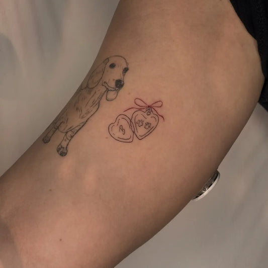 Small Fine Line Dog with Hearts Tattoo on Women Arm by @lemon.juice.tatts