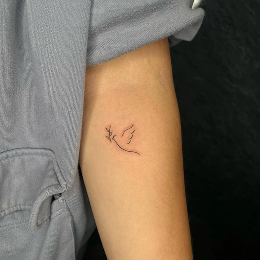 Small Fine Line Dove with Olive Branch Tattoo on Women Forearm by @emilydoxey.tattoos