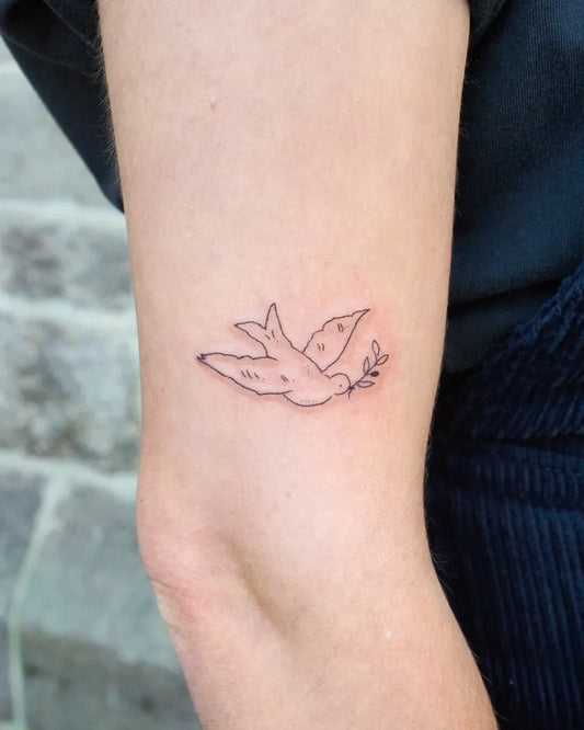 Small Fine Line Dove with Olive Branch Tattoo on Women Forearm by @sophiejeantattoo