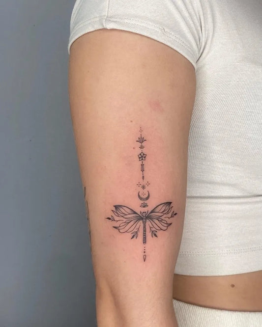 Small Fine Line Dragonfly Tattoo on Women Bicep by @d.lawlesstattoo