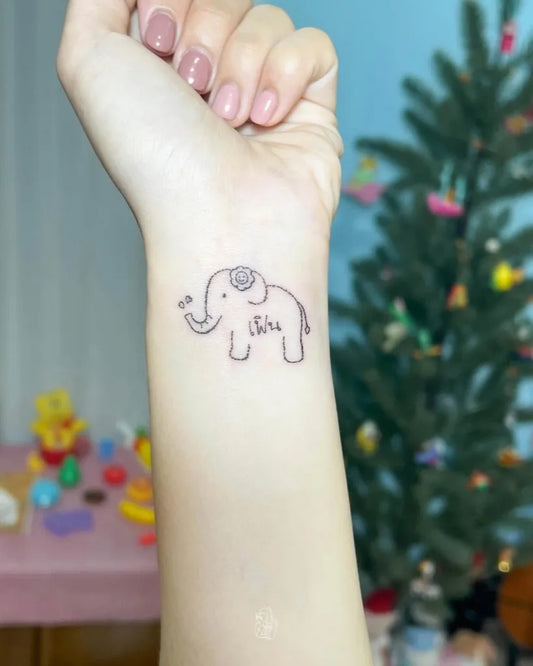 Small Fine Line Elephant with Flower Tattoo on Women Wrist by @summerry_tattoo