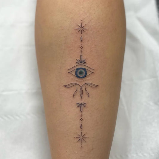 Small Fine Line Evil Eye on Women Leg Tattoo by @saffronfowlertattoos.x
