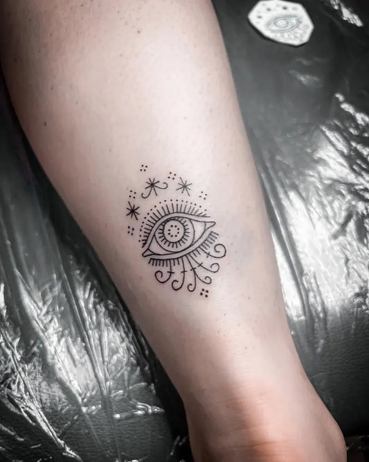 Small Fine Line Evil Eye with Stars and Swirls on Women Leg Tattoo by @tattoostudiomorocco