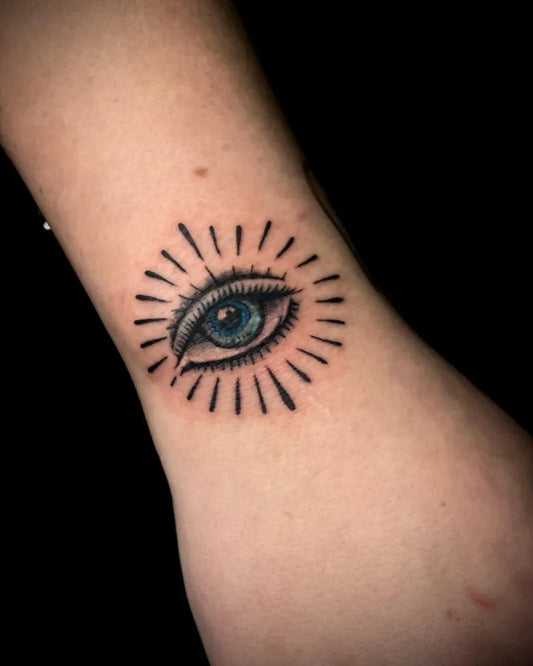 Small Fine Line Eye with Rays on Women Wrist Tattoo by @tattoosbymanik