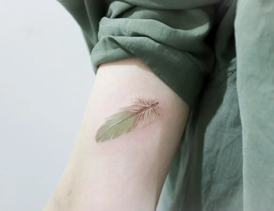 Small Fine Line Feather Tattoo on Women Arm by @tattooer_nina