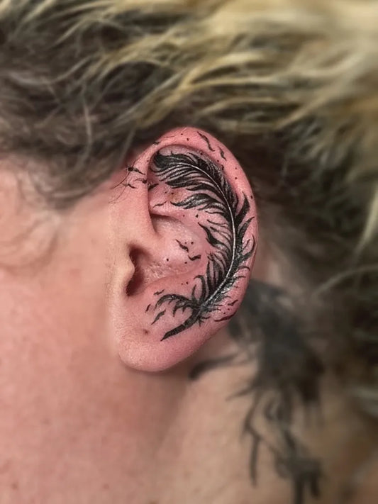 Small Fine Line Feather Tattoo on Women Ear by @aktatouage