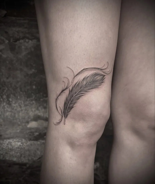 Small Fine Line Feather Tattoo on Women Knee by @ellaraintattoos