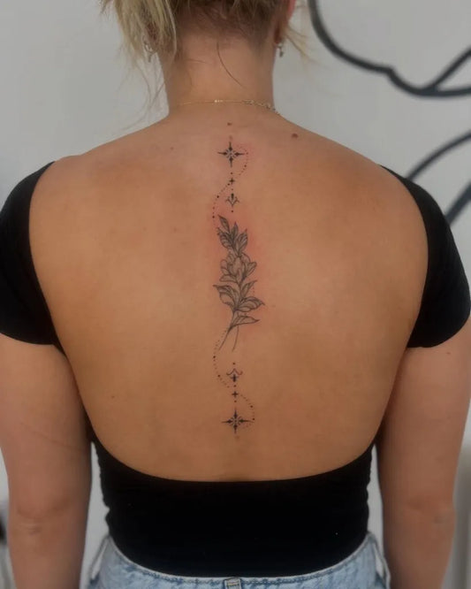 Small Fine Line Floral Branch on Women Spine Tattoo by @chloejay.tattoos