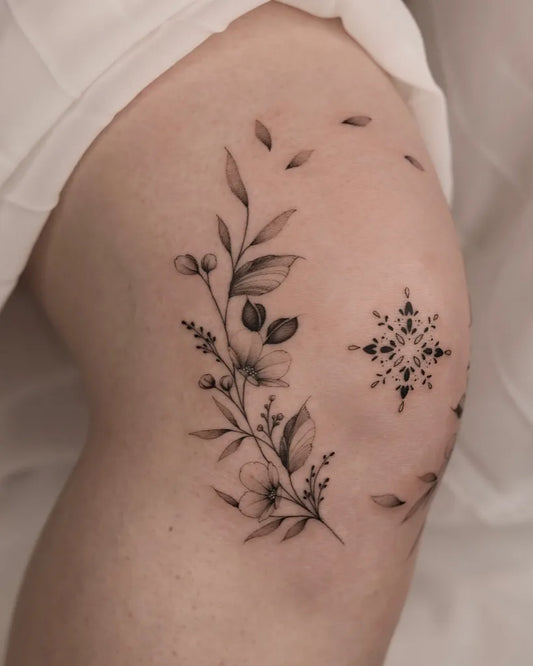 Small Fine Line Floral Snowflake Tattoo on Women Knee by @black.peony.ink