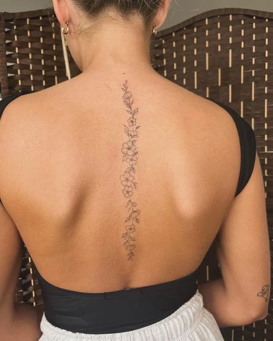 Small Fine Line Floral Vine on Women Back Tattoo by @jessicapaigetattoos