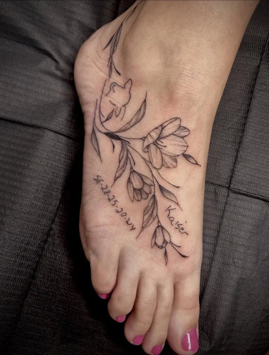 Small Fine Line Flower Vine Tattoo on Women Foot by @tinytatts_steph