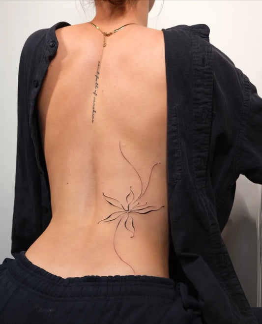 Small Fine Line Flower and Script on Women Back Tattoo by @tonii.tattoo