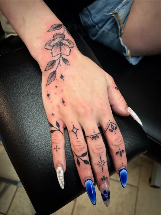 Small Fine Line Flower and Stars on Women Hand Tattoo by @graetattoos