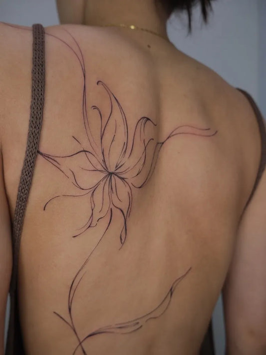 Small Fine Line Flowering Vine on Women Back Tattoo by @_gtattoos