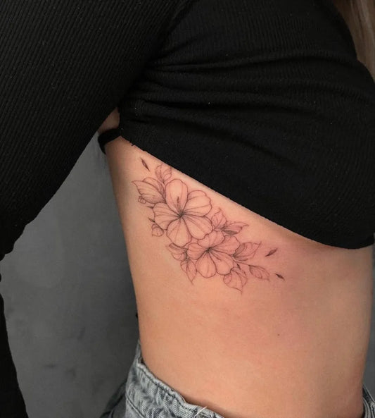 Small Fine Line Flowers Women Rib by @tattoosb