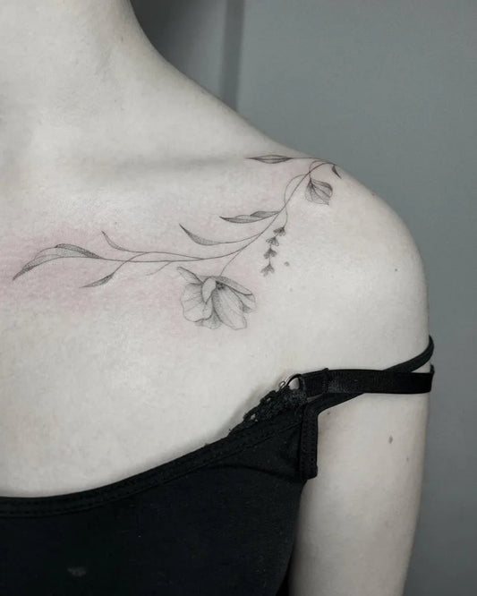 Small Fine Line Flowers and Leaves Tattoo on Women Collarbone by @dunkelbunt.tattoo