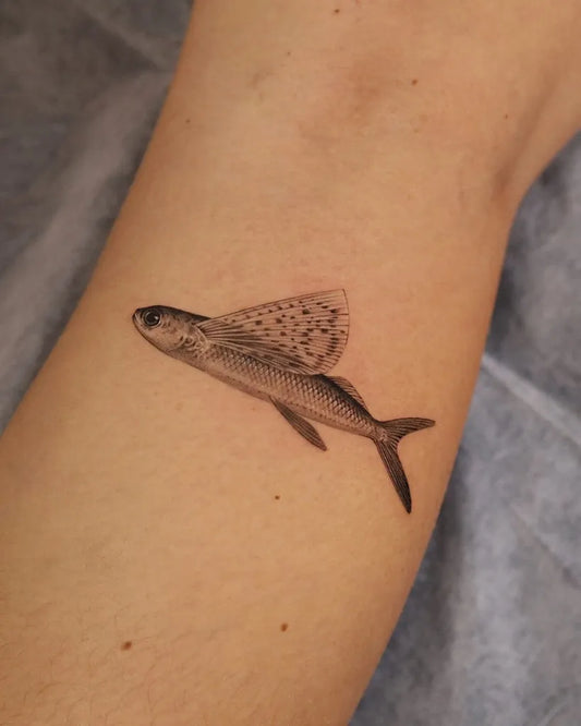 Small Fine Line Flying Fish Tattoo on Women Forearm by @yonder.tattoo