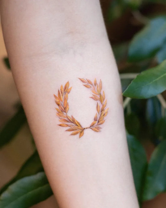 Small Fine Line Gold Laurel Wreath Tattoo on Women Arm by @suya_ink