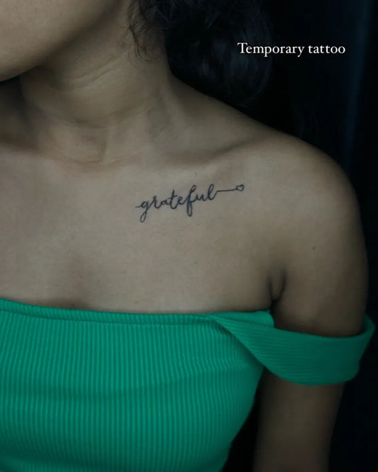 Small Fine Line Grateful Word Tattoo on Women Collarbone by @art_by_prerna22