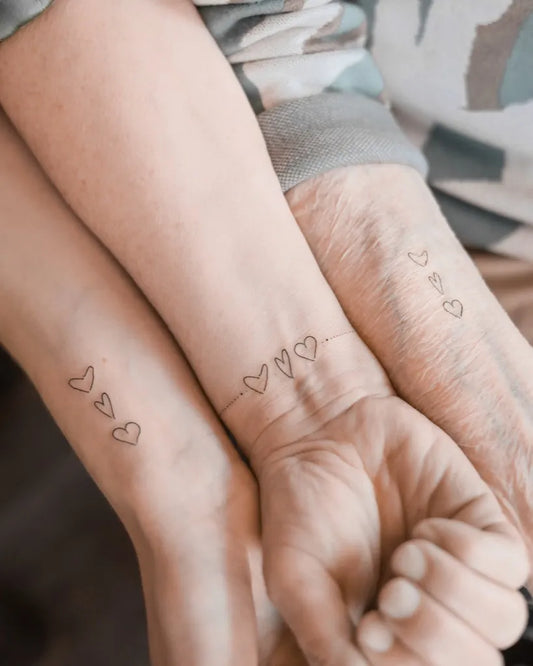 Small Fine Line Heart Family Tattoo on Women Wrist by @the_moderndayhippie_tattoo