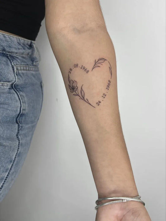 Small Fine Line Heart with Flowers and Dates on Women Arm Tattoo by @inked_by_ken