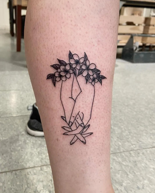 Small Fine Line Holding Hands With Flowers Tattoo on Women Calf by @lady_teapot_tattoo