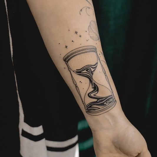 Small Fine Line Hourglass Tattoo on Women Arm by @anna.k.tattoo.art