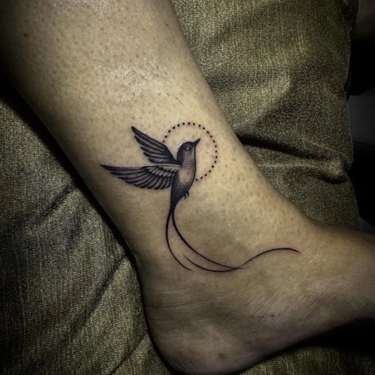 Small Fine Line Hummingbird Tattoo on Women Leg by @krijuestattoostudio_