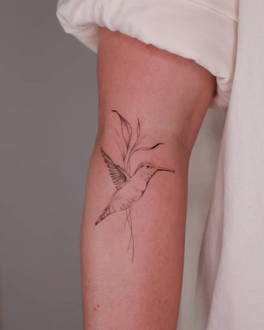 Small Fine Line Hummingbird on Women Arm Tattoo by @titletattoostudios