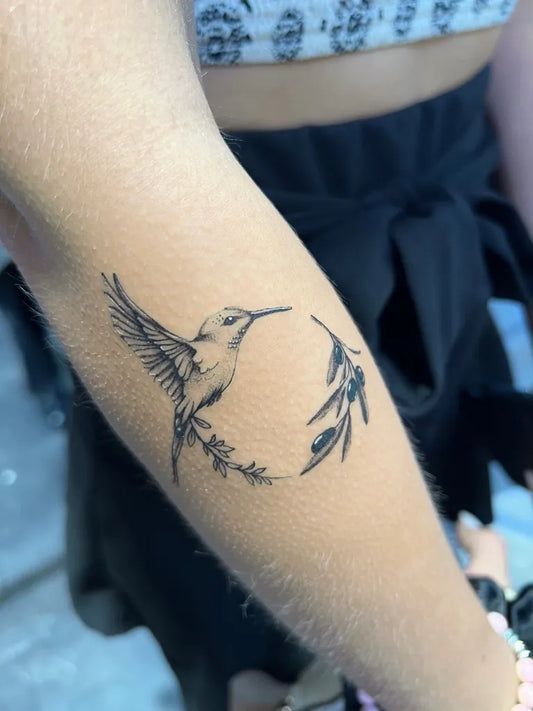 Small Fine Line Hummingbird with Olive Branch on Women Arm Tattoo by @bonna.tattoo