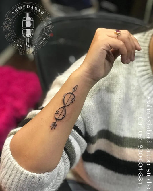 Small Fine Line Infinity Arrow Tattoo on Women Wrist by @ahmedabad_tattoo_studio
