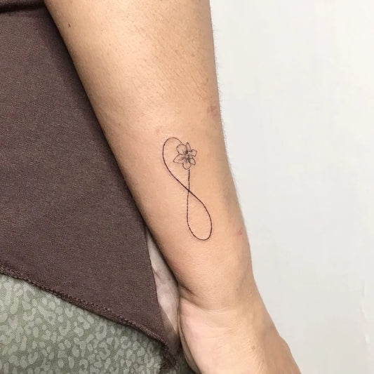 Small Fine Line Infinity Flower Tattoo on Women Arm by @tulumbeachtattoo