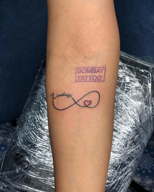 Small Fine Line Infinity Heart Tattoo on Women Forearm by @bombay.tattoo9