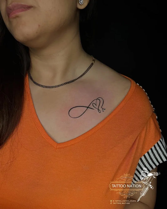 Small Fine Line Infinity Heart Tattoo on Women Shoulder by @tattoo_nation_studio