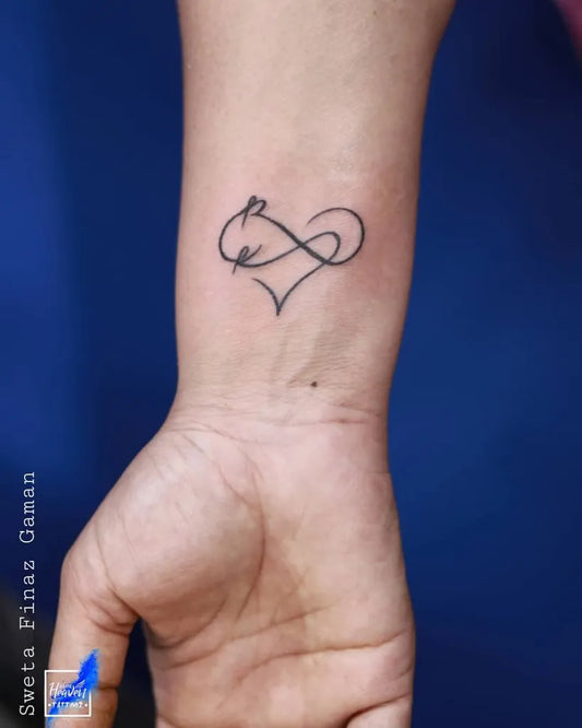 Small Fine Line Infinity Heart Tattoo on Women Wrist by @blue_heaven_tattooz