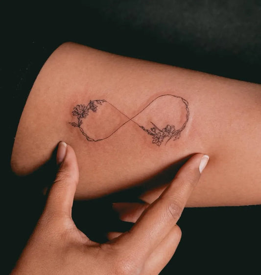 Small Fine Line Infinity and Flowers Tattoo on Women Arm by @bolchat.ink
