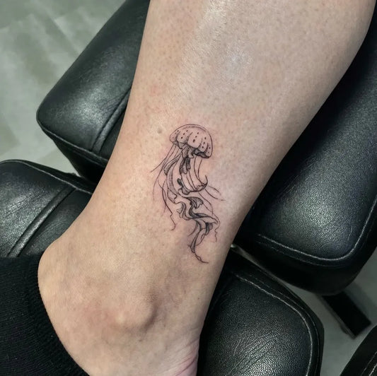 Small Fine Line Jellyfish Tattoo on Women Ankle by @emmaa.tattoo