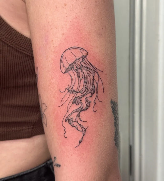Small Fine Line Jellyfish Tattoo on Women Arm by @amberwilliamstattoos
