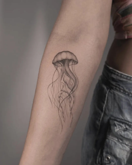 Small Fine Line Jellyfish Tattoo on Women Arm by @eden_tattoos