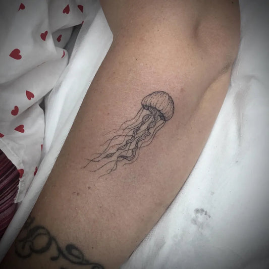 Small Fine Line Jellyfish Tattoo on Women Arm by @ninjabreadboy